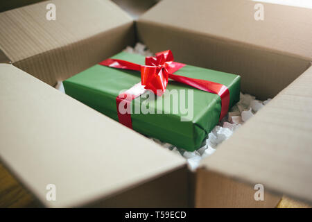 Parcel with gift box inside. Open parcel with present inside Stock Photo