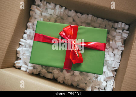 Parcel with gift box inside. Open parcel with present inside Stock Photo
