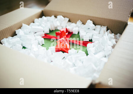 Parcel with gift box inside. Open parcel with present inside Stock Photo