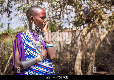 MASAI VILLAGE, KENYA - OCTOBER 11, 2018: Unindentified african woman wearing traditional clothes in Masai tribe, Kenya Stock Photo