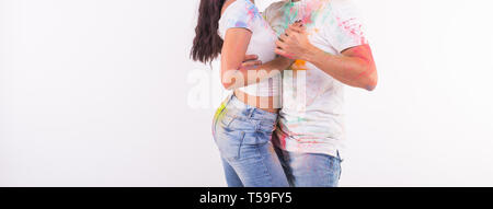 Holiday, social dance, holi and people concept - Close up of couple having fun covered in paint and dancing bachata or kizomba on white background Stock Photo