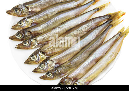 Smoked capelin on a white plate close-up isolated Stock Photo