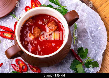 Goulash traditional homemade European beef meat stew soup, Hungarian bograch, close-up, on wooden table. Stock Photo