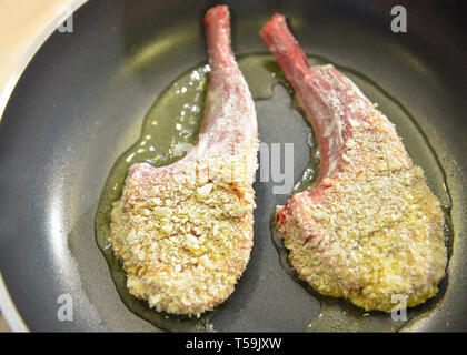 Chef preparing food, meal, in the kitchen, Rack of lamb frying on pan Stock Photo