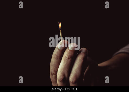 Burning match in the man's hand. Dangerous game with fire. Stock Photo