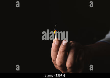 Burning match in the man's hand. Dangerous game with fire. Stock Photo