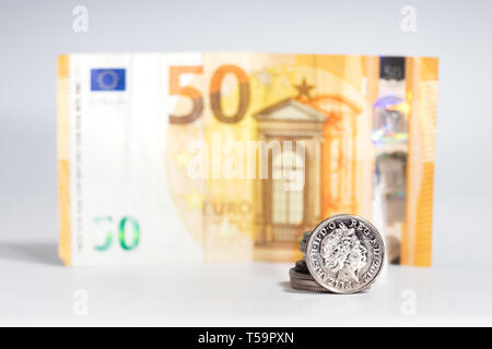 A five pence coin with the image of Elizabeth II over a blurred 50 euros banknote, Brexit concept. Stock Photo