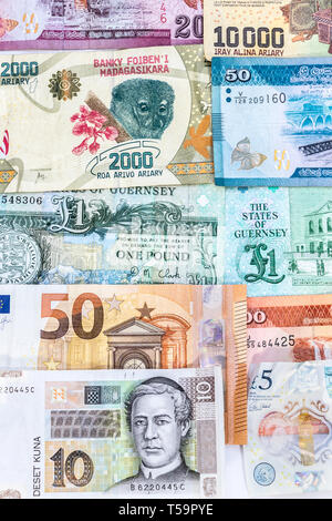 Banknotes background with currency from Guernsey, Madagascar, Croatia, UK and Europe. Stock Photo
