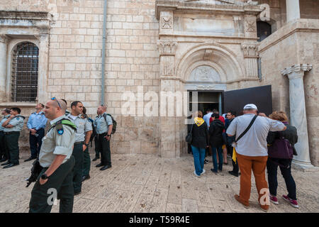 A group of Israeli officers stands near St. George the Dragon Slayer Church in Lod (Liddya), while pilgrims enter the church. Stock Photo