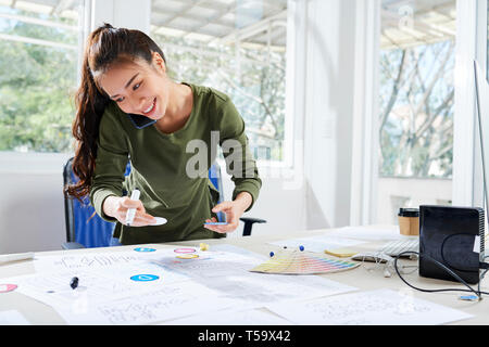 App developer working with sketches while being on phone Stock Photo