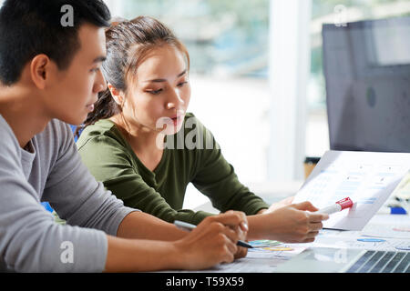 Designer pointing at sketches of interface Stock Photo