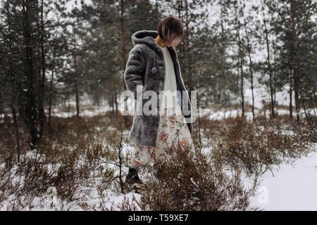 A woman walks in the woods in winter Stock Photo