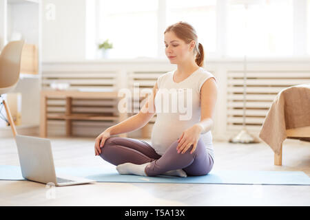 Pregnant Woman practicing Home Meditation Stock Photo