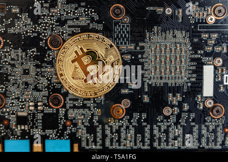 Bitcoins lie on the video card, concept of mining. Electronic virtual money for web banking and international network payment. Symbol of crypto curren Stock Photo