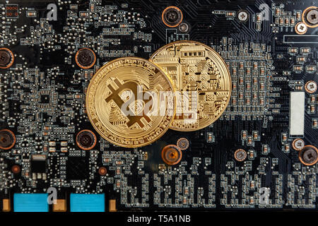 Bitcoins lie on the video card, concept of mining. Electronic virtual money for web banking and international network payment. Symbol of crypto curren Stock Photo