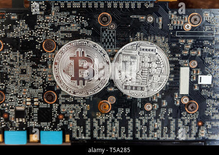 Bitcoins lie on the video card, concept of mining. Electronic virtual money for web banking and international network payment. Symbol of crypto curren Stock Photo