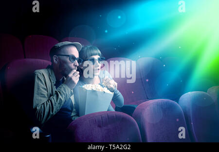 Teenager couple cuddling and watching the climax part of the movie Stock Photo