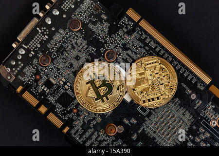Bitcoins lie on the video card, concept of mining. Electronic virtual money for web banking and international network payment. Symbol of crypto curren Stock Photo