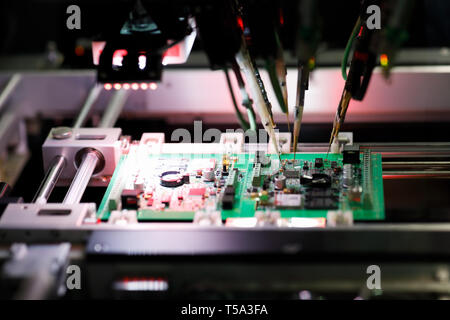 Printed circuit board assembly during a flying probe In-circuit test on flying probe tester system. Selective focus. Stock Photo