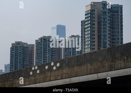 Outlines of fish affixed to the outer wall of the West Kowloon Highway in Hong Kong. In the distance is the International Commerce Center Stock Photo