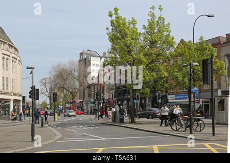 Bus lane in the centre of Catford,South London, UK. Shows shops, traffic lights and pedestrians. Stock Photo