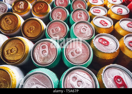 Metal cans of beer with ice cubes in mini refrigerator, close up. Lots of aluminum cans in the ice in the open fridge. Drops of water on a cold can of Stock Photo