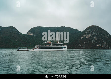 cruising among beautiful limestone rocks and secluded beaches in Ha Long bay, UNESCO world heritage site, Vietnam. Stock Photo