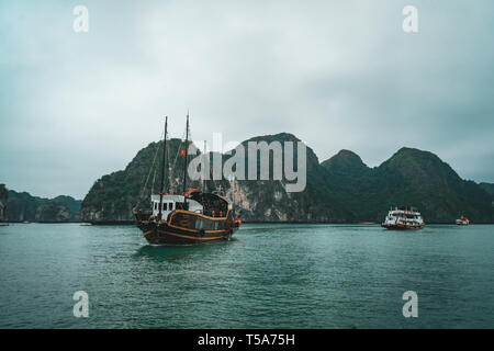 cruising among beautiful limestone rocks and secluded beaches in Ha Long bay, UNESCO world heritage site, Vietnam. Stock Photo