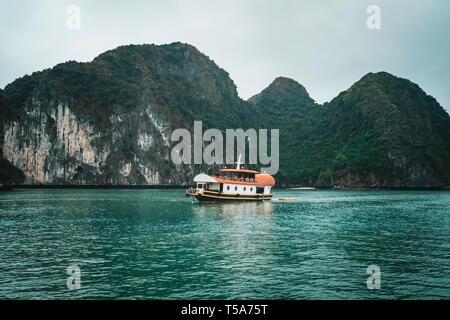 cruising among beautiful limestone rocks and secluded beaches in Ha Long bay, UNESCO world heritage site, Vietnam. Stock Photo