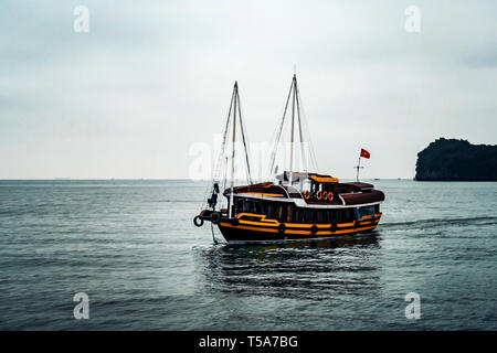 cruising among beautiful limestone rocks and secluded beaches in Ha Long bay, UNESCO world heritage site, Vietnam. Stock Photo