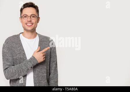 Smiling Caucasian man in glasses pointing at copy space isolated Stock Photo