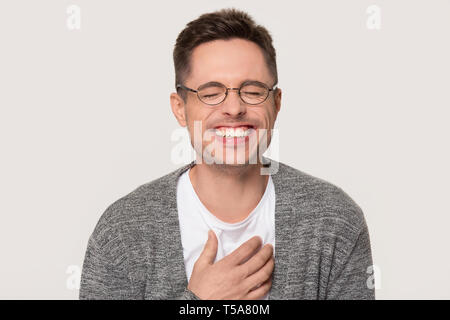 Caucasian man in glasses laughing isolated on grey background Stock Photo