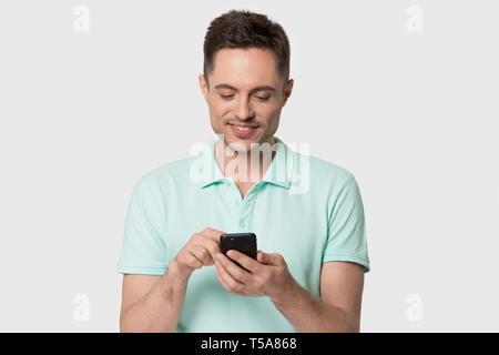 Smiling man isolated on background using smartphone Stock Photo