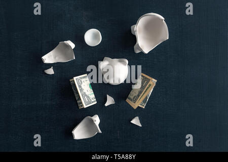 Dollars in broken piggy coin bank, money savings in home budget and finances concept Stock Photo