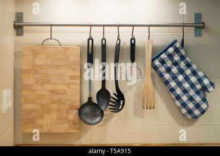 kitchen utensils hanging on the wall Stock Photo