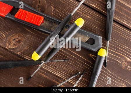 Lot of whole work item scalpel knife and screwdrivers flatlay on brown wood Stock Photo