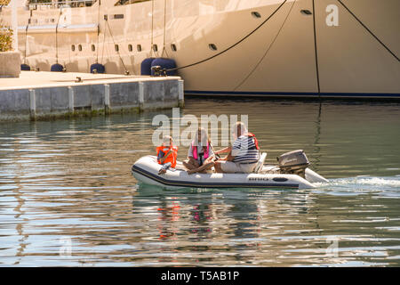 CANNES, FRANCE - APRIL 2019: Family in a small dinghy with outboard motor in the Port Pierre Canto marina in Cannes Stock Photo