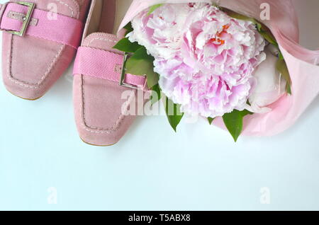 Light pink suede leather ballerina flats shoes with blush pink peonies bouquet wrapped in a tissue paper with copy space Stock Photo