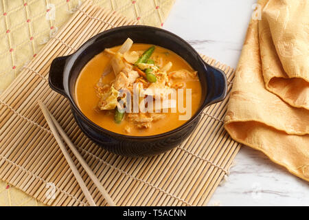 Thai food spicy coconut milk panang curry soup with chicken string beans onions and napa cabbage Stock Photo