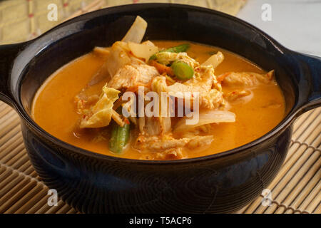 Thai food spicy coconut milk panang curry soup with chicken string beans onions and napa cabbage Stock Photo