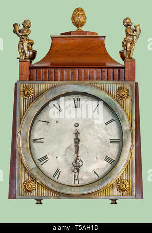 Antique mantel clock of brass children statuettes, on isolated green background with clipping path. Stock Photo