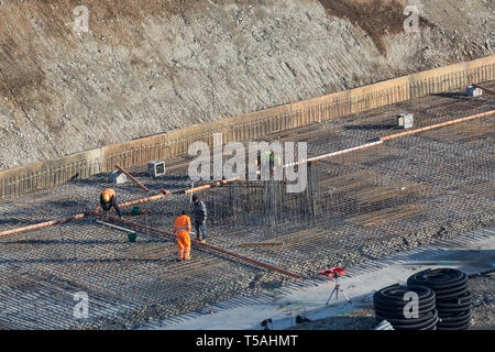 Construction of the building. Workers unrecognizable make metal reinforcement for the concrete foundations Stock Photo