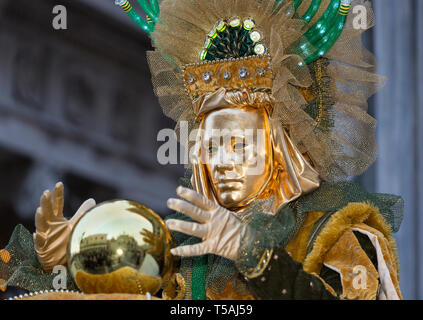 Fortune teller, street performer wearing gold mask and costume, Venice Carnival, Italy Stock Photo