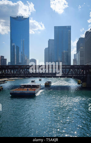 Downtown Chicago urban landscape with a ferry on Chicago River going ...