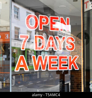 Open 7 days a week sign in shop window Stock Photo