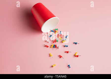 collection of colorful pushpins isolated on pink background. office tool. top view photo Stock Photo
