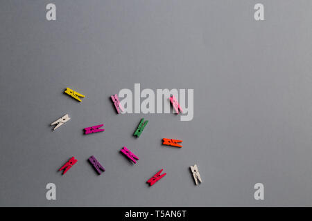 multicolored clothes pegs on the gray background. copy space. top view Stock Photo