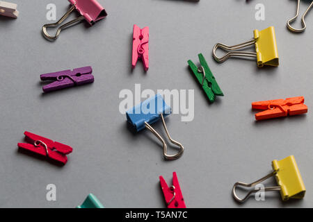 multiculored paper clips and clothespins on gray background. top view Stock Photo