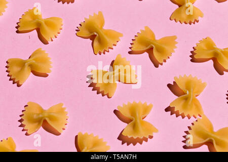 bow tie pasta isolated on pink background. top view Stock Photo