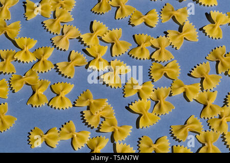 Some raw macaroni from the best sorts of wheat isolated on blue background, top view photo Stock Photo